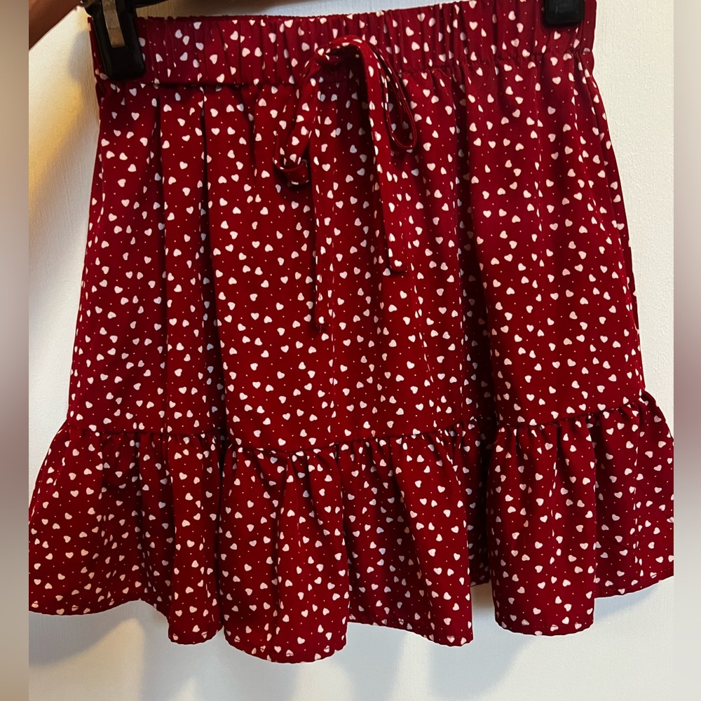 Super cute and trendy flowy red skirt with white hearts and tie in front
